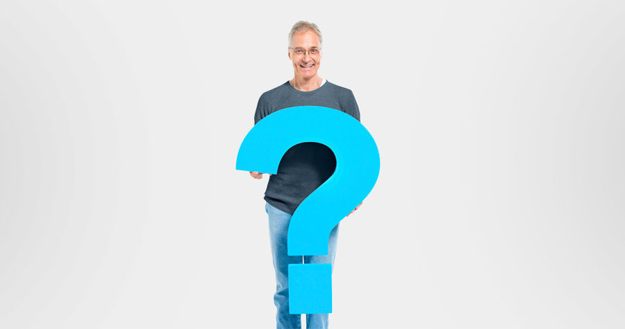 Homem de 50 anos segurando um ponto de pergunta para questionar: quais são os sintomas mais comuns do câncer de próstata?"